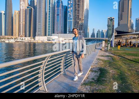 Young man walking at the promenade in Dubai Marina. Stock Photo