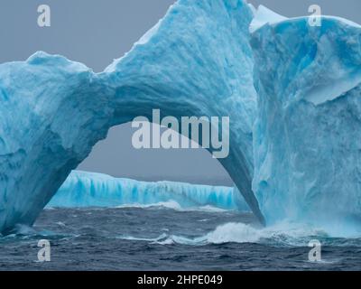 A blue iceberg arch off the South Orkney Islands, Antarctica Stock Photo