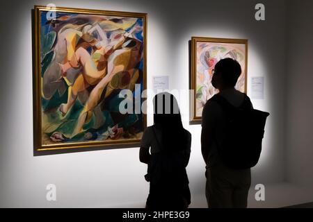 Silhouette of man and woman looking at a piece of painting in an art gallery Stock Photo