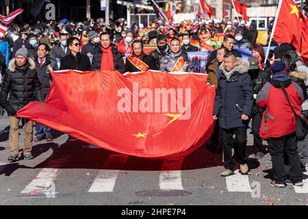 New York, USA. 20th Feb, 2022. Atmosphere during Lunar New Year parade in Manhattan Chinatown in New York on february 20, 2022. Thousands of people participated and watched the parade along the streets of Chinatown. Lion dance, dragon dance, flags of the USA and People's Republic of China, floats and some political statements were seen on the parade route. Participants carrying huge flag of China. (Photo by Lev Radin/Sipa USA) Credit: Sipa USA/Alamy Live News Stock Photo