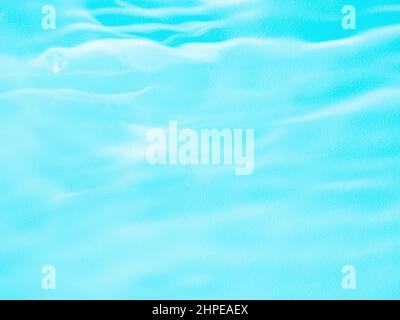 Ripple water texture on blue pool background. Shadow of water on sunlight. Mockup for product, spa or travel background. Marble blue water surface as wallpaper background Stock Photo