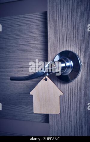 Key with keychain in form house in door lock Stock Photo