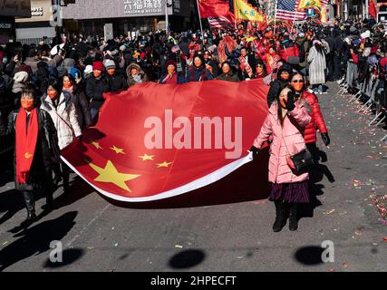 New York, New York, USA. 20th Feb, 2022. Atmosphere during Lunar New Year parade in Manhattan Chinatown. Thousands of people participated and watched the parade along the streets of Chinatown. Lion dance, dragon dance, flags of the USA and People's Republic of China, floats and some political statements were seen on the parade route. Participants carry huge China flag (Credit Image: © Lev Radin/Pacific Press via ZUMA Press Wire) Stock Photo