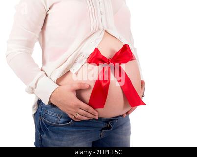 red ribbon tied around the belly of a pregnant woman on white background Stock Photo