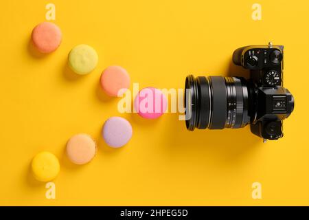 Light spectrum, color theory and photography concept. Colorful macarons designed as light waves with a camera. Stock Photo