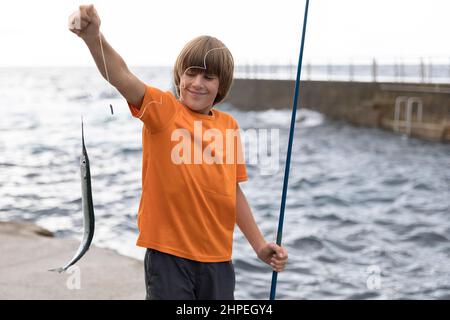 Boy child hold fish he caught fishing by mountain pond Stock Photo - Alamy