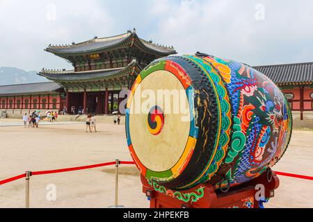 Seoul, South Korea - July 24, 2021: Ceremonial drum in front of the Geunjeongmun Gate and Corridor of Gyeongbokgung Palace. Colourful traditional drum Stock Photo