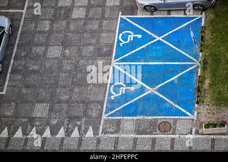Empty parking lot with car spaces reserved for people with disabilities, aerial view.