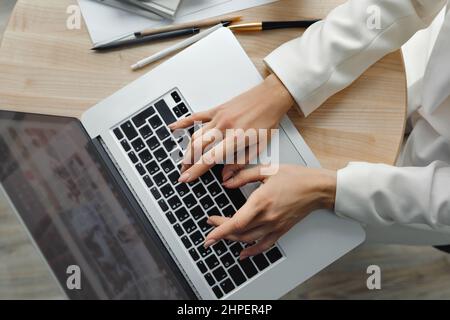 Woman working at laptop computer hands close up. Hand on keyboard close up Closeup of a female hands busy typing on a laptop. Working at home. Quarant Stock Photo