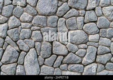 Texture of a gray stone wall. Texture background of the stone wall of the old castle. Stone wall as a background or texture. Stock Photo