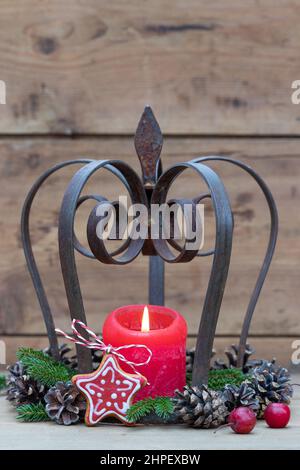 christmas decoration with iron crown, red candle and pine cones Stock Photo