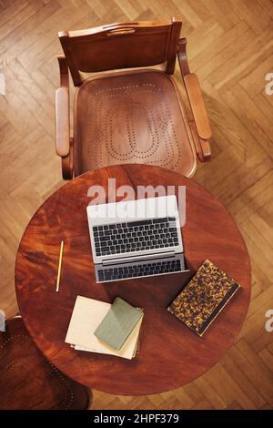 Vertical top view background of cozy working space with laptop in classic library Stock Photo