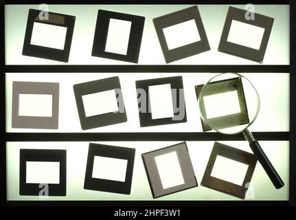 light table  with empty photographic slides and  magnifying glass,blank picture frames. anlog photography mock up. Stock Photo