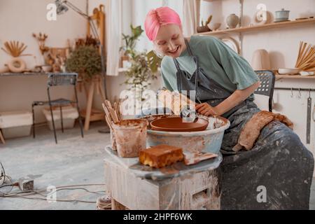 Young female master working with clay in pottery room Stock Photo
