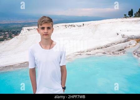 Portrait of an emotional young man in white clothes aged 14-17 in Pamukkale, Turkey. Stock Photo
