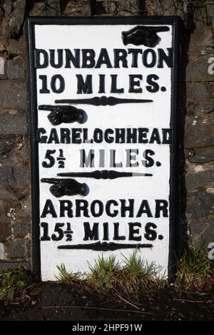 Black and withe painted metal Mile marker at Rhu showing the distance to local towns, Dunbarton, Garelochhead and Arrochar, in Argyll, Scotland Stock Photo