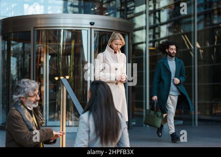 Business people walking and talking outside the office building. Stock Photo