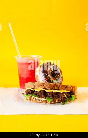 Rye bread pulled beef sandwich with donut and slush drink Stock Photo