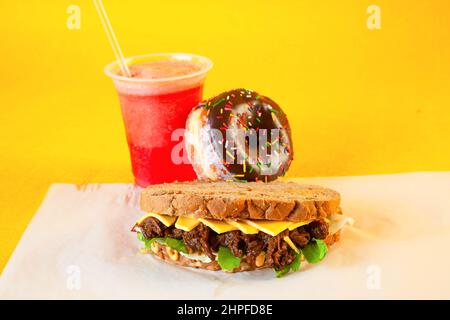 Rye bread pulled beef sandwich with donut and slush drink Stock Photo