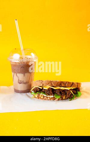 Rye bread pulled beef sandwich with donut and iced coffee drink Stock Photo