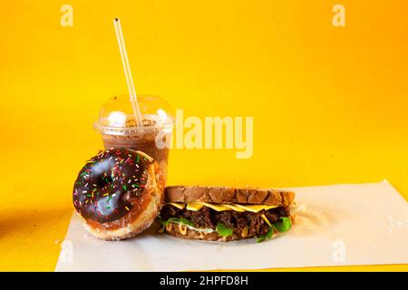 Rye bread pulled beef sandwich with donut and iced coffee drink Stock Photo