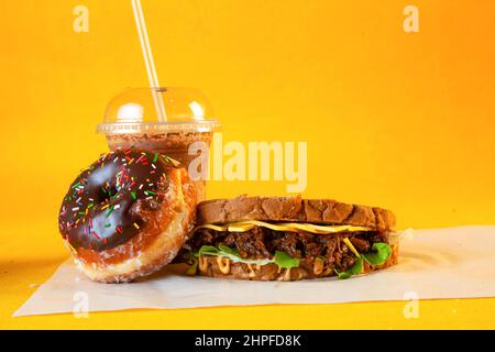 Rye bread pulled beef sandwich with donut and iced coffee drink Stock Photo