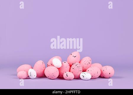 Pink Easter quail eggs on violet background with copy space Stock Photo