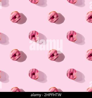 pattern made of Freshly baked donuts for breakfast on a pink background . Sweet background. Bakery, baking concept. Stock Photo