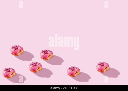 pattern made of Freshly baked donuts for breakfast on a pink background . Sweet background. Bakery, baking concept. Stock Photo