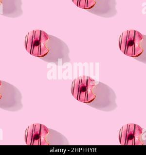 pattern made of Freshly baked donuts for breakfast on a pink background . Sweet background. Bakery, baking concept. Stock Photo