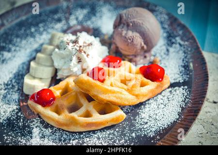 Breakfast with wholegrain brussels waffles and whipped cream, redberries Stock Photo