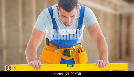 Male caucasian construction worker using level while working at side Stock Photo
