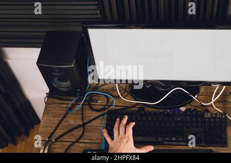 top view of caucasian hands on a computer keyboard producing music in a home studio, music production and music industry concept. Stock Photo