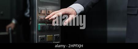 cropped view of man pressing button in modern elevator, banner Stock Photo