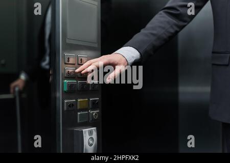 cropped view of man pressing button in modern elevator Stock Photo