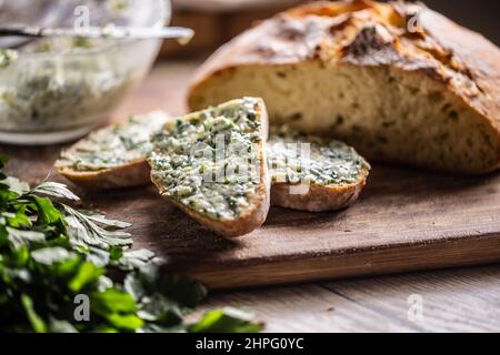 Simple appetizer in a form of bread slices with herb butter on top. Stock Photo