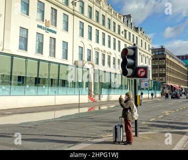 Glasgow, Scotland, UK 21st February, 2022. UK  Weather:  Storms end and we await more bad weather as locals take advantage to enjoy the sun and normal life for a day The millenium hotel always in the news as its rundown state may necessitate demolition. .Credit Gerard Ferry/Alamy Live News Stock Photo