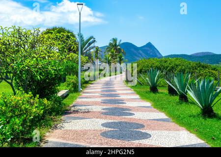 Pedestrian walkway with flooring in red, black and white pattern. Camboinhas beach if a famous place and a travel destination in the State of Rio de J Stock Photo