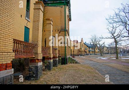 The setting sun shines on a row of damaged buildings at Fort Hancock in Sandy Hook, New Jersey, USA -50 Stock Photo