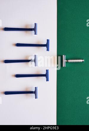 A comparison of plastic and eco-friendly razors on a green flat lay Stock Photo