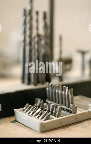 Close up of tools drill bit on wooden work table Stock Photo