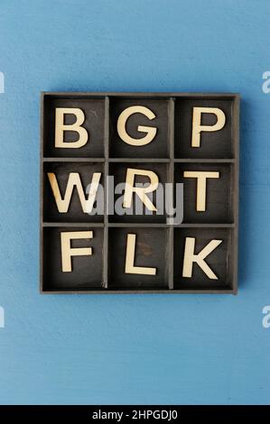 wooden box with compartments filled with consonant letters Stock Photo