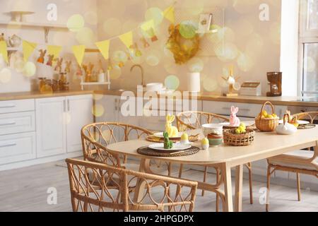 Festive table setting for Easter dinner in kitchen Stock Photo