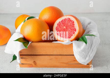 Box with delicious grapefruits on light background Stock Photo