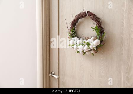 Beautiful Easter wreath hanging on door Stock Photo