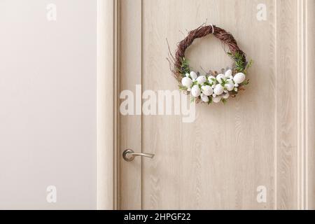 Beautiful Easter wreath hanging on door Stock Photo