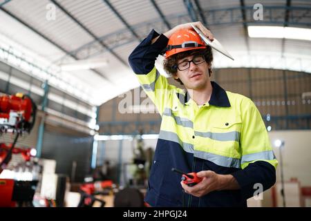 engineer checking control panel and teaching new Automatics robot arm and operating control machine in factory. Stock Photo