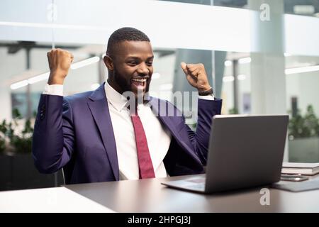 Happy african american boss using computer, gesturing Stock Photo