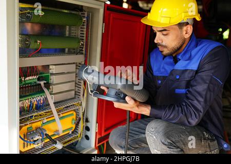 engineer checking control panel and teaching new Automatics robot arm and operating control machine in factory. Stock Photo