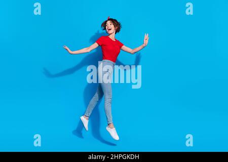 Full size profile side photo of young pretty girl go jump look empty space curious isolated over blue color background Stock Photo